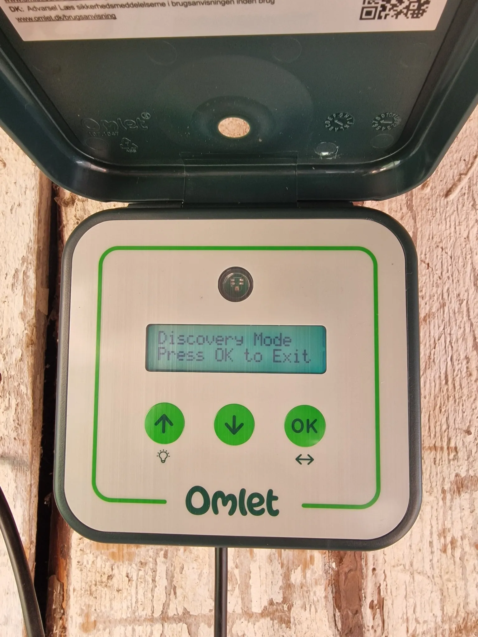 Styringsboksen til Omlet Smart Autodoor med display og knapper for opp, ned og OK.